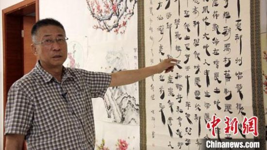 圖為朱群和他的敦煌漢簡(jiǎn)書(shū)體?！「攥?攝