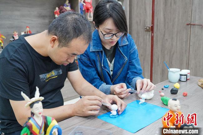 <a target='_blank'  data-cke-saved- >中新社</a>記者(右)現(xiàn)場體驗面塑制作過程?！￡悹帍?攝