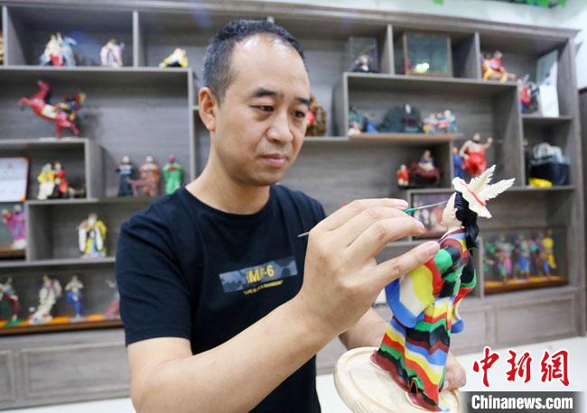 圖為安秋平正在創(chuàng)作代表隴南文縣民俗的《白馬人》作品?！「哒?攝