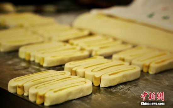 圖為面劑被涂上胡麻油，切成條狀用作月餅的花型制作。張文 攝