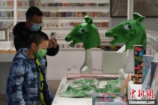 圖為“神馬來了”銅奔馬頭套吸引參觀者駐足。　九美旦增 攝