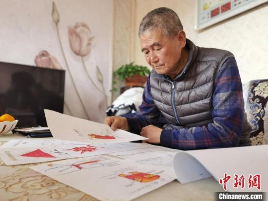 圖為陸鵬飛向記者展示多年帶隊(duì)的手寫筆記?！堟?攝