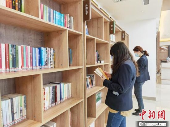 圖為在甘肅公航旅建設(shè)集團(tuán)有限公司的職工書屋，職工挑選書籍。　徐雪 攝