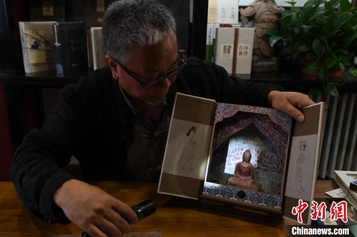 圖為讀者出版集團讀者晉林工作室獨立出品人徐晉林，展示互動性強的敦煌題材手工書。(資料圖) 楊艷敏 攝