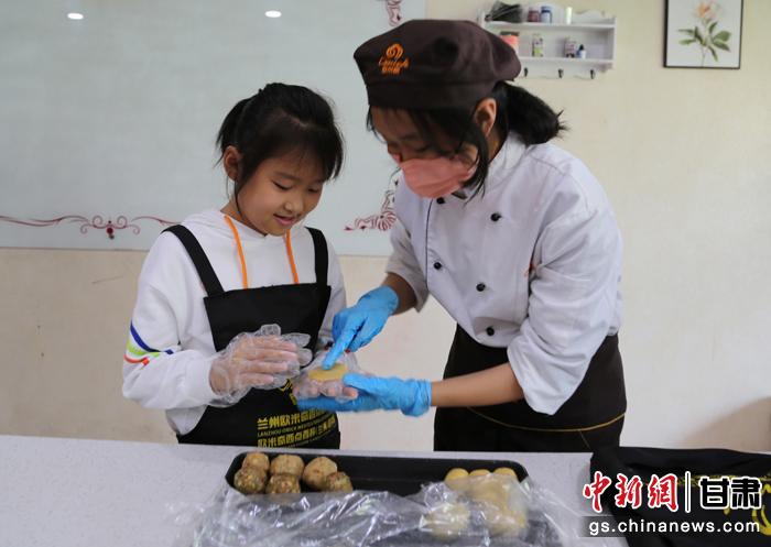 圖為在甘臺(tái)胞小朋友在工作人員指導(dǎo)下制作月餅。九美旦增 攝