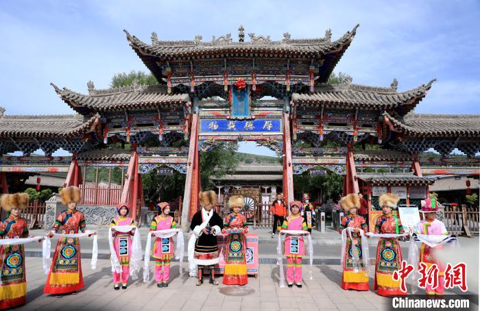 圖為身穿土族服飾的工作人員迎接訪客?！⊙Φ?攝