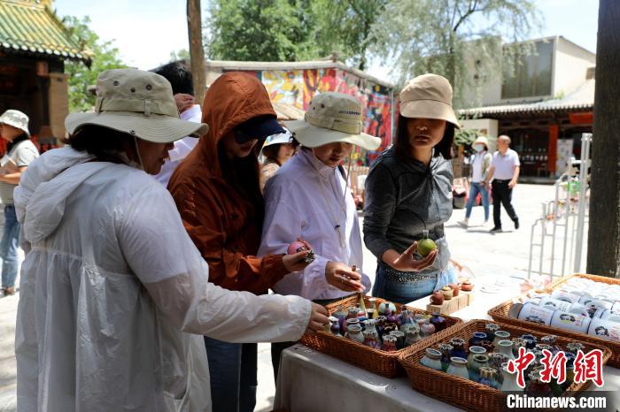 圖為民眾挑選手工藝產(chǎn)品?！⊙Φ?攝