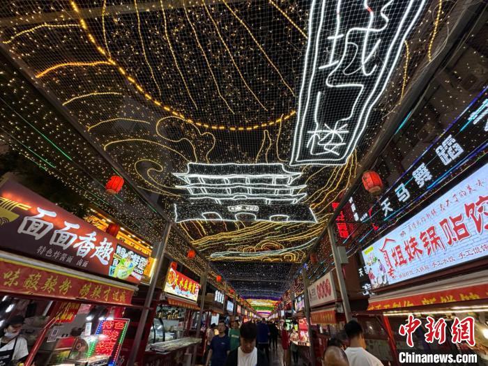 圖為明清街夜市燈光點(diǎn)亮具有武威文化元素的“涼州古城門”彩燈?！〈魑牟?攝</p><p>