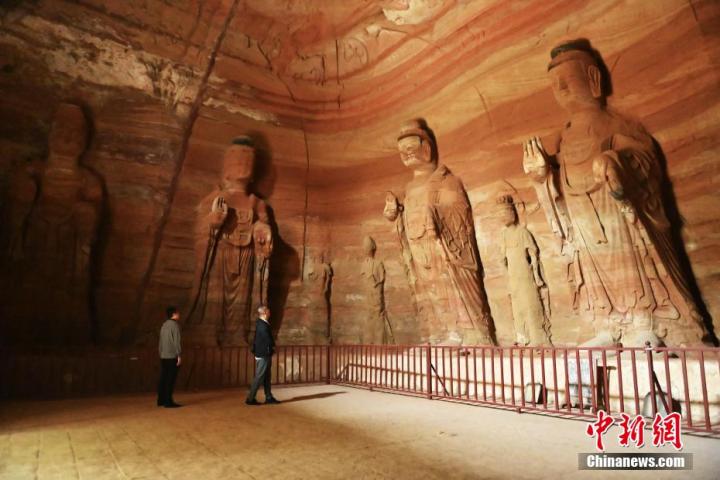 7月15日，游人參觀甘肅省平涼市涇川縣百里石窟長廊中的南石窟寺1號窟。百里石窟長廊位于涇川縣境內，由512個石窟、5眼窟中石井組成，現(xiàn)存王母宮石窟、鳳凰山石窟、南石窟寺、丈八寺石窟、羅漢洞石窟、太山寺石窟等規(guī)模較大的石窟群，還有數量眾多的小石窟群。南石窟寺開鑿于北魏永平三年，其中1號窟屬于大型七佛窟，七佛高達6米。中新社記者 李亞龍 攝