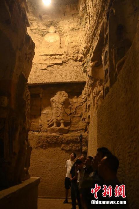 7月15日，游人參觀甘肅省平涼市涇川縣百里石窟長廊中的王母宮石窟。百里石窟長廊位于涇川縣境內，由512個石窟、5眼窟中石井組成，現(xiàn)存王母宮石窟、鳳凰山石窟、南石窟寺、丈八寺石窟、羅漢洞石窟、太山寺石窟等規(guī)模較大的石窟群，還有數量眾多的小石窟群。王母宮石窟又名千佛洞，該窟設計宏大，造像生動，窟內擁有造像數百尊，是較為珍貴的佛教文化遺存。中新社記者 李亞龍 攝</p>
<p>