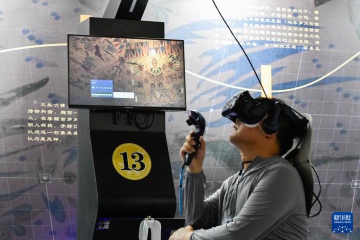 7月22日，游客借助VR設(shè)備沉浸式游覽莫高窟第285窟虛擬場(chǎng)景。新華社記者 郎兵兵 攝